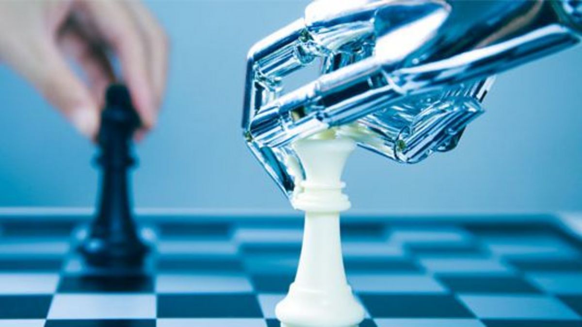 Die Hand eines Roboters bewegt eine Figur auf dem Schachfeld. Im Hintergrund wird der nächste Zug von einer Menschenhand vorbereitet.