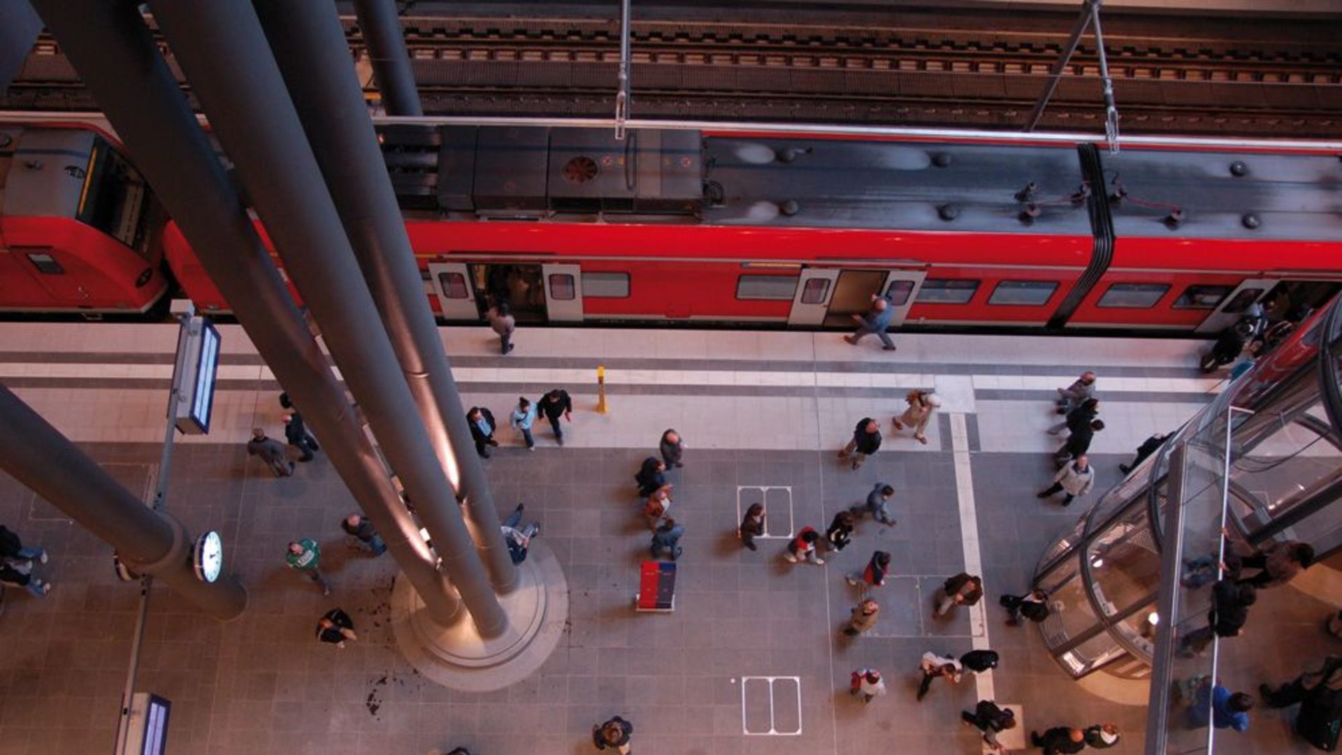 An einem Bahnhof steht eine SBahn an einem Gleis zum Ein- und Ausstieg bereit. 
