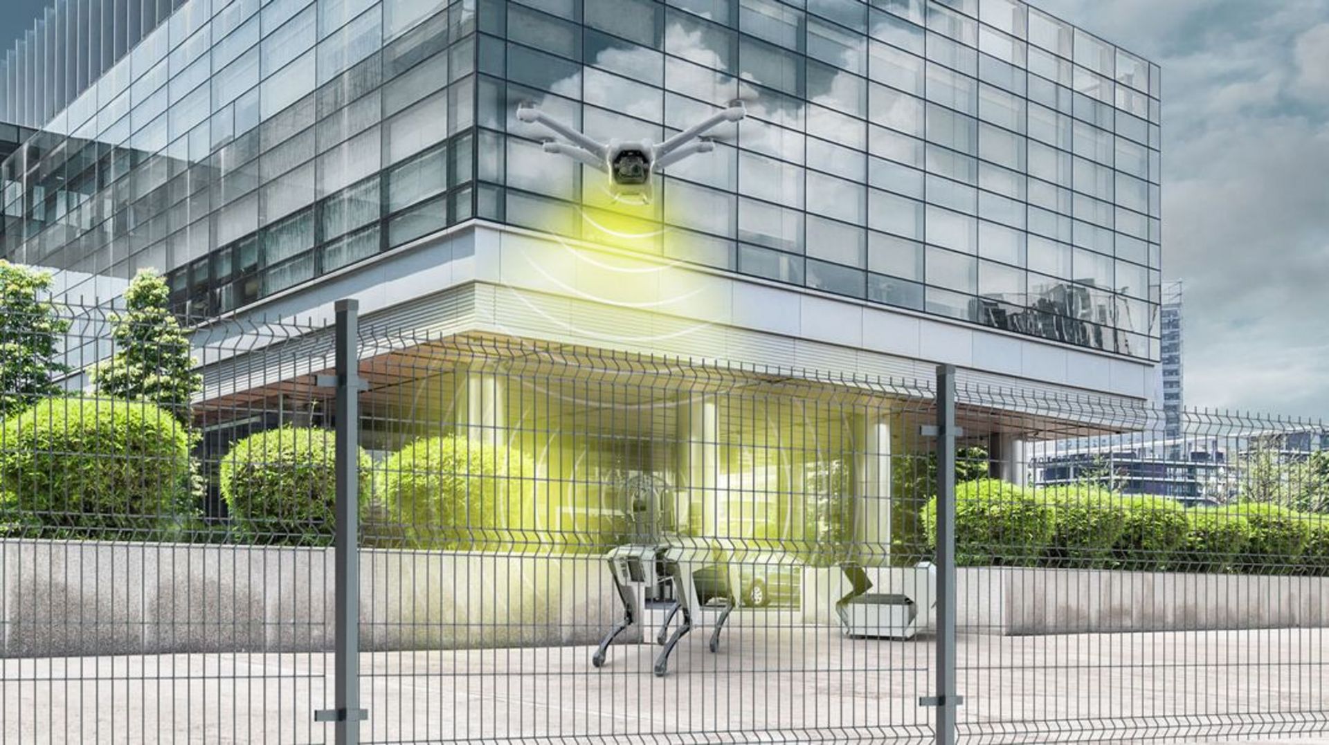 Vor einem Gebäude hinter einem Zaun sind Robotiksicherheitssysteme zu sehen. 