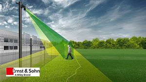 Ein Videosicherheitsystem zeigt einen Überwachungsstrahl, der eine Person auf einem offenen Gelände erfasst. Das Bild zeigt eine Überwachungskamera an einem Zaun, die in grünen und gelben Farben den Bereich abdeckt, der überwacht wird. Im Hintergrund sind Gebäude und ein grünes Feld zu sehen. Das Bild ist mit dem Logo von Ernst & Sohn versehen, einem Wiley-Brand.