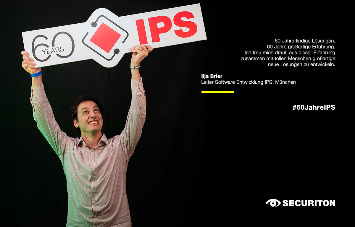 Eine Person streckt das 60 Jahre IPS Logo in die Luft. Rechts daneben steht ein Glückwunsch zum Geburtstag.